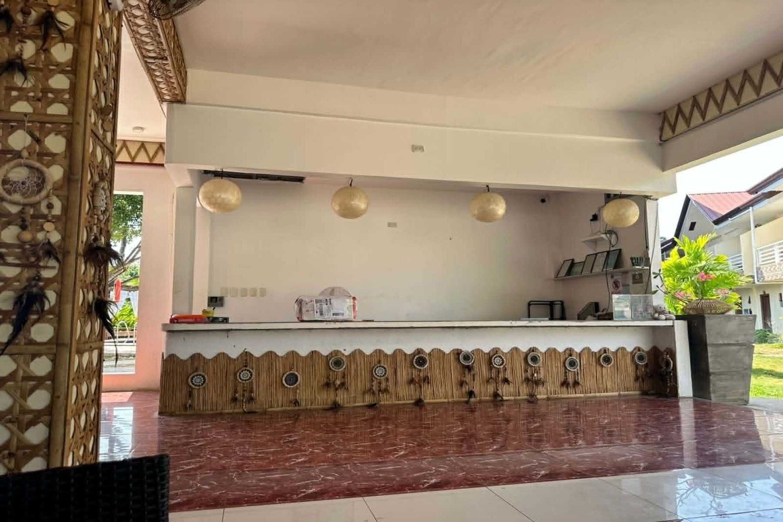 A reception area with a counter, decorative wall, and hanging lights.