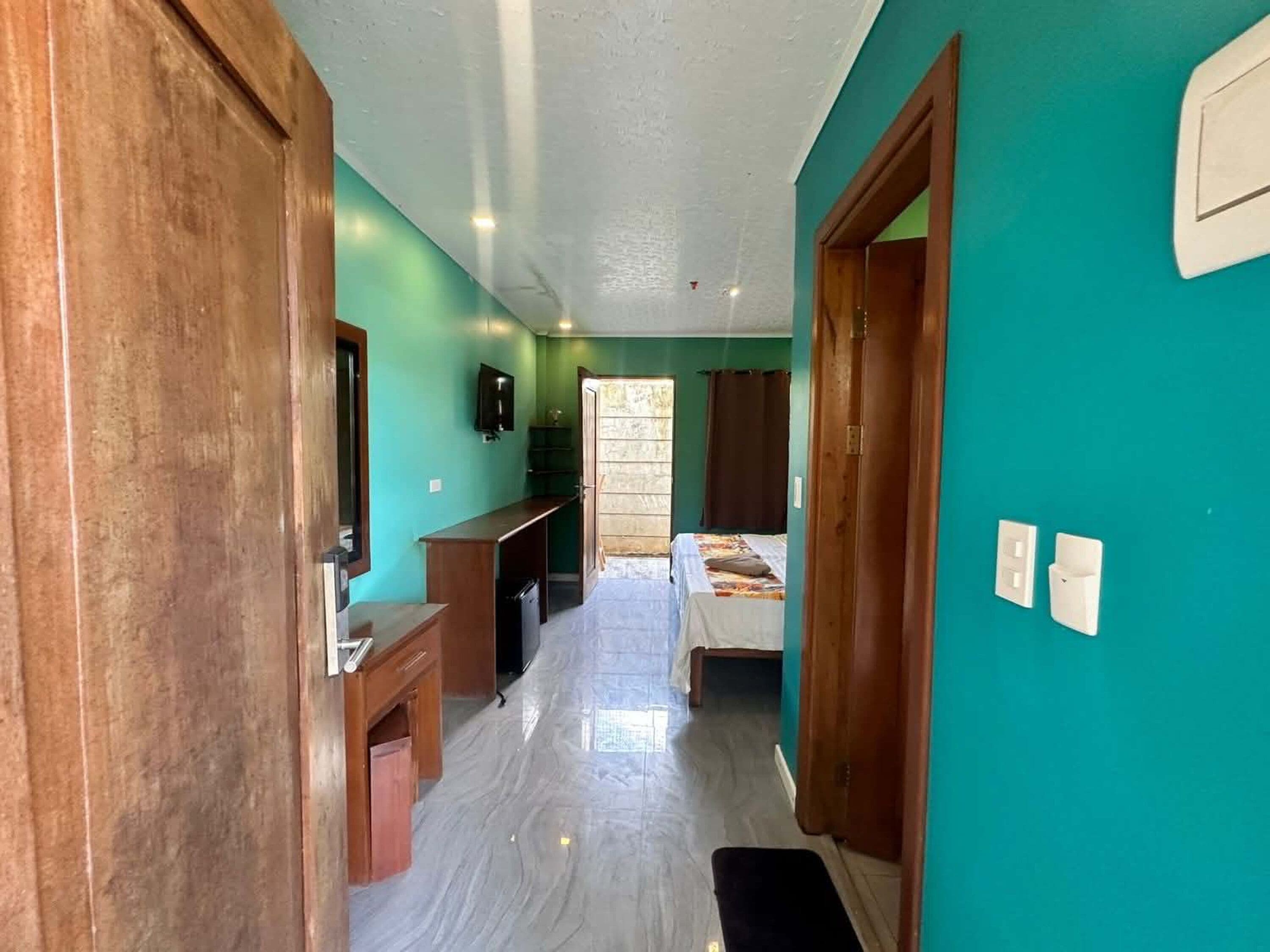 A room with a bed, a desk, a TV, and a window.