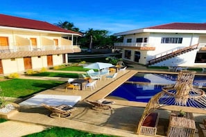 A pool area with lounge chairs, a small table, and a staircase leading to a balcony. - Palette Lifestyle Pangnao Resort Bohol (Panglao)