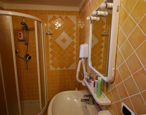A bathroom with a shower, a sink, and a mirror. - Le Corti Di Marinella 4p Garden View (Marinella)