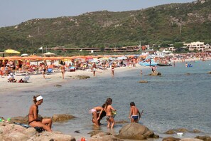 A beach with people, umbrellas, and boats. - Le Corti Di Marinella 4p Garden View (Marinella)