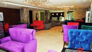 A lobby with plush seating, marble columns, and a modern chandelier. - Hotel Akbar International (Rawalpindi)