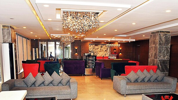 A lobby with sofas, a bar area, and a chandelier. - Hotel Akbar International (Rawalpindi)