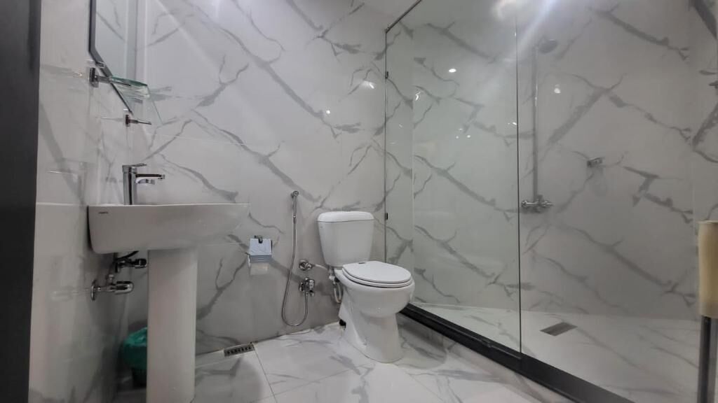 Un baño moderno con inodoro, ducha y lavamanos.