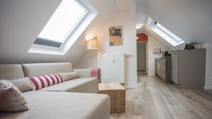 A modern loft apartment with a high ceiling, skylights, a kitchenette, and a cozy seating area. - Appartement - Winterbergerstrasse 3, nr. 511 | Neuastenberg (Winterberg)