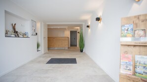 A hallway with a wooden door, a black rug, and a plant. - Appartement - Winterbergerstrasse 3, nr. 511 | Neuastenberg (Winterberg)