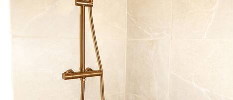 A shower with a handheld showerhead and a handheld hose.