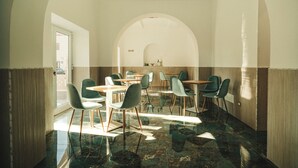 A dining area with tables and chairs, a large arched doorway, and a view of the outside. - Hotel Mediterraneo (Santa Marinella)