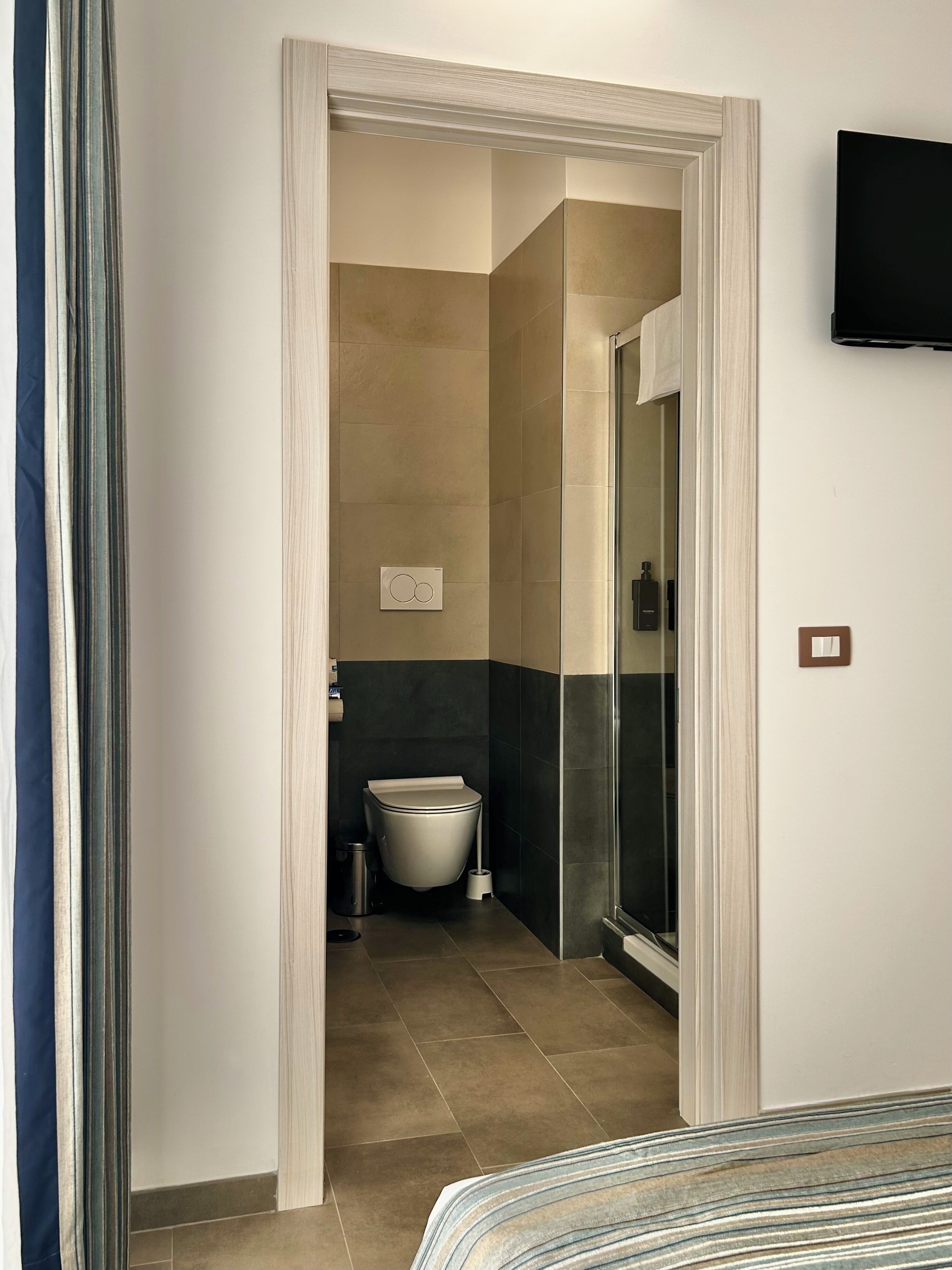 Een moderne badkamer met toilet, wastafel en douche.