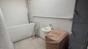 A small, enclosed bathroom with a toilet, sink, and shower area. - Furnished studio apartment in Vila Amália, North Zone (São Paulo)
