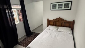 A bedroom with a bed, a window with curtains, a ceiling light, and three framed pictures on the wall. - Furnished studio apartment in Vila Amália, North Zone (São Paulo)