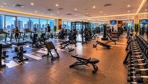 Ein Fitnessstudio mit Laufbändern, Kraftgeräten und Kurzhanteln.