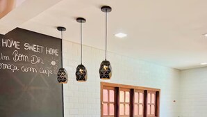 A modern kitchen with a chalkboard wall, pendant lights, wooden stools, and a built-in island.