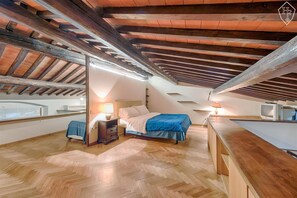 Un dormitorio con cama, mesita de noche, lámpara y televisión.