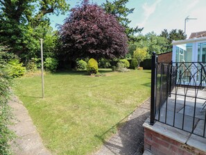 A well-maintained garden with a lawn, a metal fence, and a brick structure. - 51 Colin Mclean Road (Dereham)