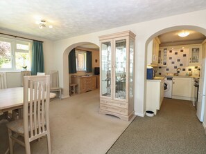 A compact kitchen with a dining area, a cabinet, and a washing machine. - 51 Colin Mclean Road (Dereham)
