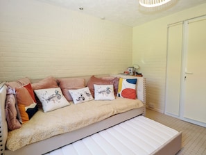 A room with a sofa, pillows, a small table with a mirror, and a wardrobe. - 51 Colin Mclean Road (Dereham)