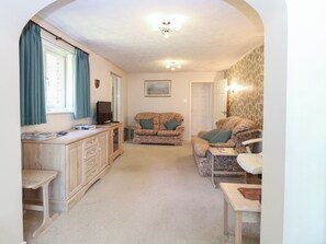 A compact living space with a sofa, a small table, a TV, and a cabinet.