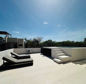 A rooftop terrace with a modern design, featuring a seating area with lounge chairs and a built-in air conditioning unit. - Spacious 4BR Villa in Tulum (Tulum)