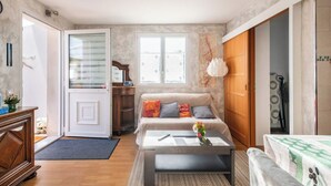 A living room with a sofa, coffee table, and a wooden cabinet. - A39, Exit N*5, T1: Quiet/Peaceful/Relaxing/Safe. Sleeps 2 (140/200) + pets (Tréclun)