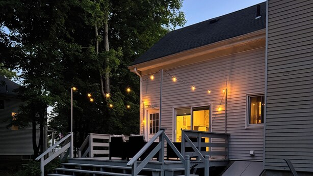 A house with a porch, steps, and string lights.