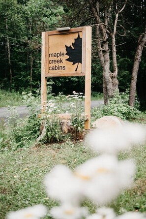 Une pancarte en bois ornée d’une feuille d’érable et d’une inscription indiquant « cabanes de Maple Creek ».