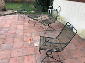A patio with metal chairs and a hose. - Classic Florida 2-bedroom house with AC in quaint DeLand (DeLand)