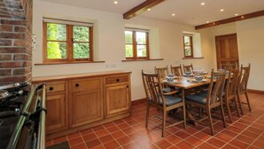 Une cuisine équipée d’une cuisinière, de meubles de rangement en bois et d’un coin repas avec une table et des chaises.