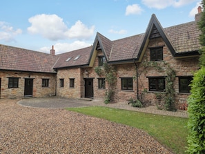 A stone building with multiple rooms, a gravel courtyard, and a sloped roof. - Stowey Mead Stables (Bristol)