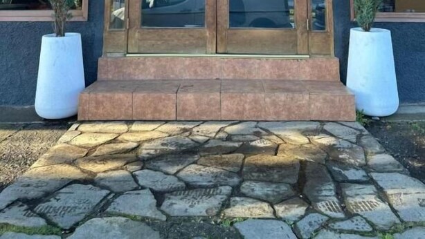 A building with a wooden facade, large glass doors, and potted plants. - Hotel Boutique Wenupillan (Villarrica)