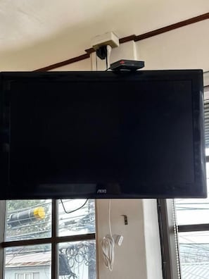 A flat-screen TV mounted on a wall with a power outlet and cable management. - Hotel Boutique Wenupillan (Villarrica)
