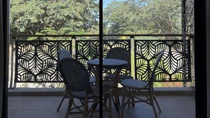 A balcony with wicker furniture and a decorative metal fence. - Luxury 2-bedroom apartment in Victoria Falls near the falls (Victoria Falls)