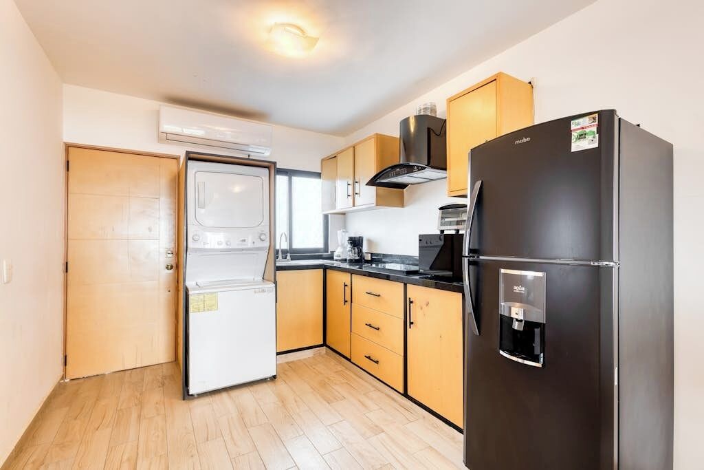A compact kitchen with a refrigerator, oven, and microwave.
