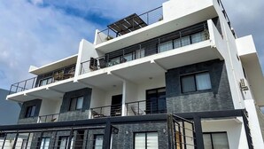 Un edificio de varios pisos con balcones, ventanas amplias y un estilo arquitectónico moderno.