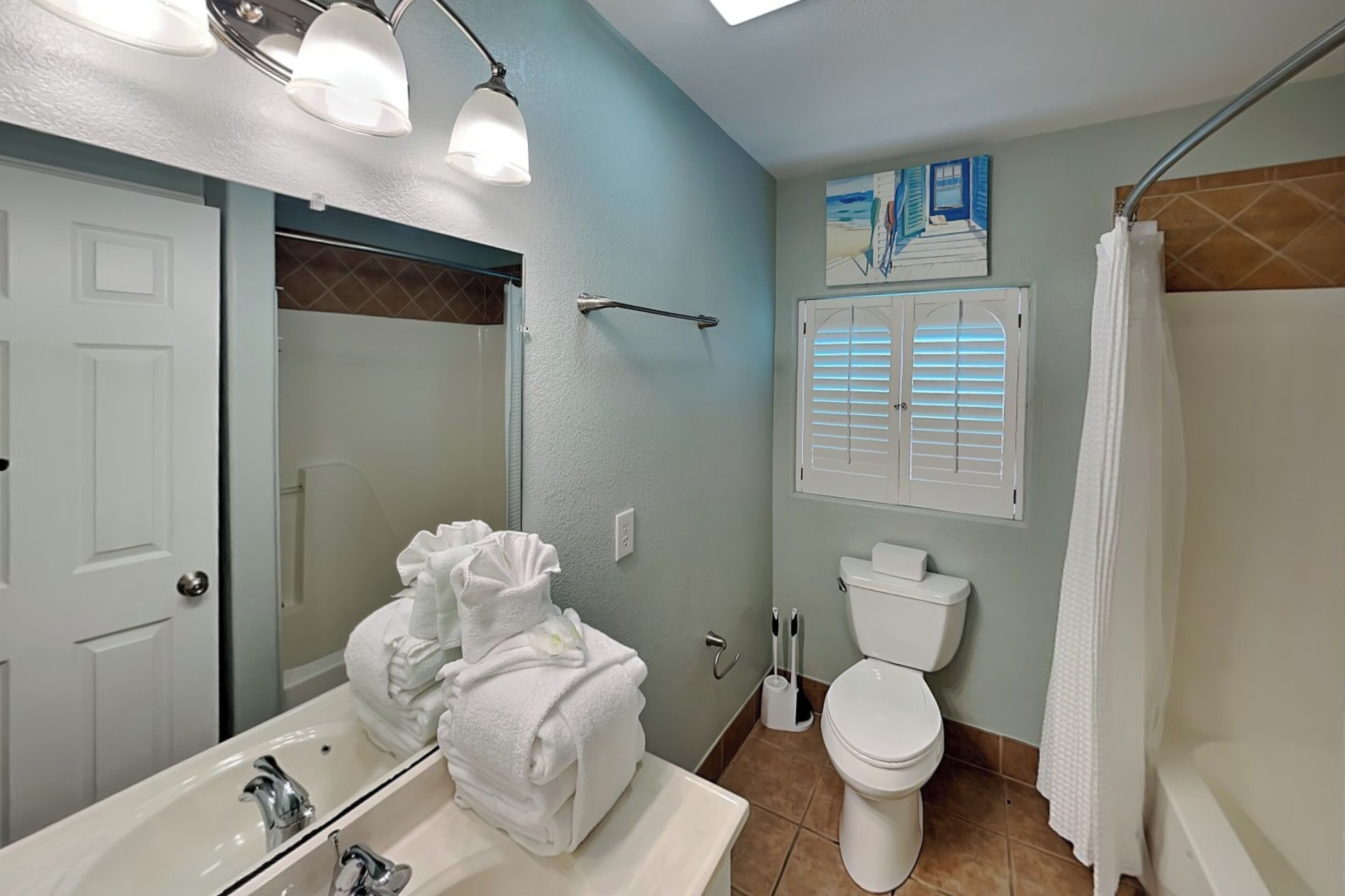 A bathroom with a sink, toilet, and shower.