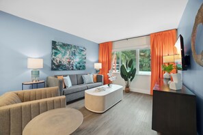 Ein modernes Wohnzimmer mit Sofa, Couchtisch und einem großen abstrakten Gemälde an der Wand.