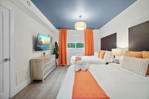 Een hotelkamer met een bed, een televisie, een houten dressoir en een raam met gordijnen.