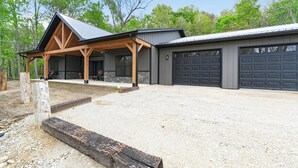 Edifici modern amb un porxo cobert, un garatge i un camí d'accés de grava.