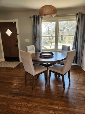 A dining area with a round table, four chairs, a woven pendant light, and a view through large windows. - 2026 FIFA WORLD CUP ATLANTA PERFECTION! Location, location, location! WELCOME! (Atlanta)