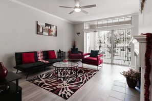 A living room with a sofa, armchairs, a coffee table, and a large window. - SAVE BIG/ Walkable Uptown Dallas 2BR/ Nightlife (Dallas)