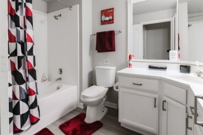 A bathroom with a bathtub, toilet, and vanity with cabinets. - SAVE BIG/ Walkable Uptown Dallas 2BR/ Nightlife (Dallas)