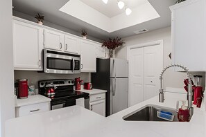 A modern kitchen with white cabinetry, stainless steel appliances, a skylight, and a kitchen island. - SAVE BIG? Walkable Uptown Dallas 2BR/ Nightlife (Dallas)