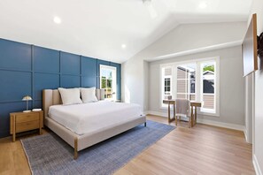 Une chambre à coucher avec un lit, une table de chevet, une chaise et une fenêtre.