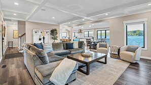 A spacious living room with a large sectional sofa, a coffee table, and a view of the water. - Waterfront Retreat - Hot Tub, Fireplace, Pier (hoodsport)
