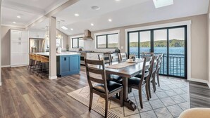 A spacious kitchen with a large island, a dining area with a view of the water, and a modern interior design. - Waterfront Retreat - Hot Tub, Fireplace, Pier (hoodsport)