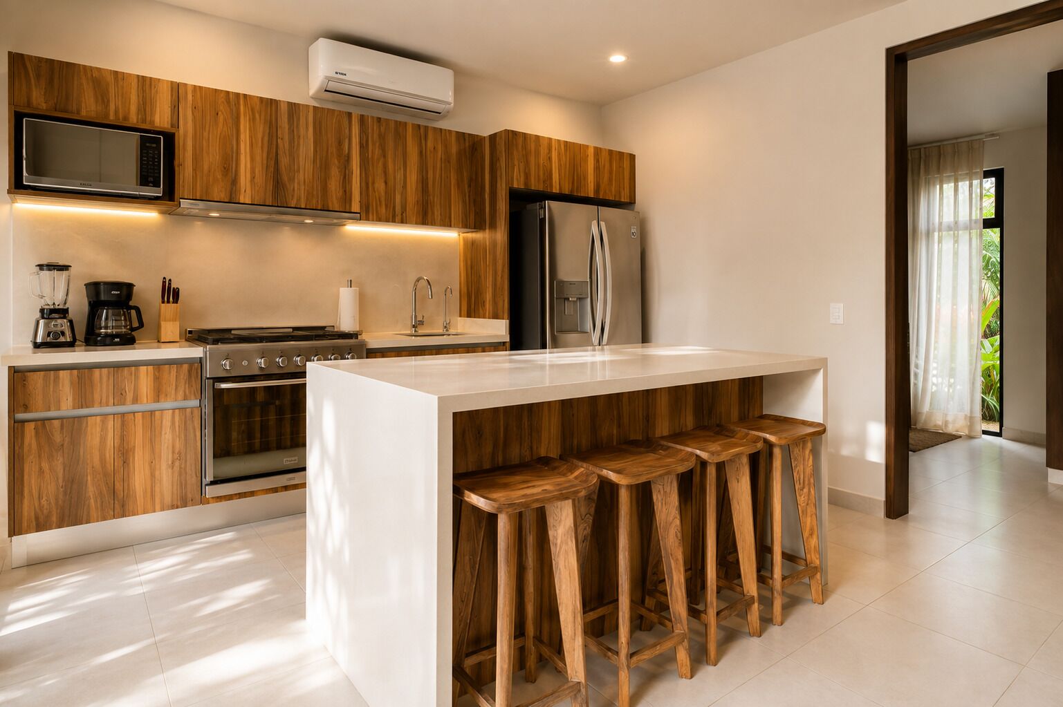 Une cuisine moderne avec des meubles en bois, un îlot central doté de tabourets, un four encastré et un réfrigérateur.
