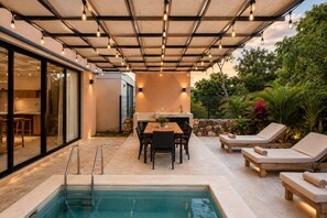 An outdoor pool area with a table and chairs, a barbecue, and lounge chairs. - Tropical 3BR Villa Retreat + Private Plunge Pool (Tulum)