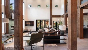 Un vaste espace de vie au design moderne, comprenant un grand canapé, une table basse et un téléviseur.