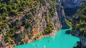 Um cânion com águas azul-turquesa e barcos.