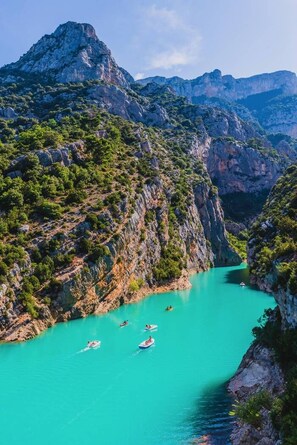 Ein Canyon mit türkisblauem Wasser und Booten.